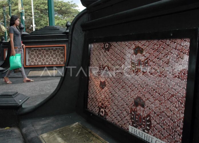 Seorang pengunjung melintasi koleksi batik yang dipajang di Monumen Batik Yogyakarta, Kawasan Nol Kilometer Yogyakarta. Foto: Antara.