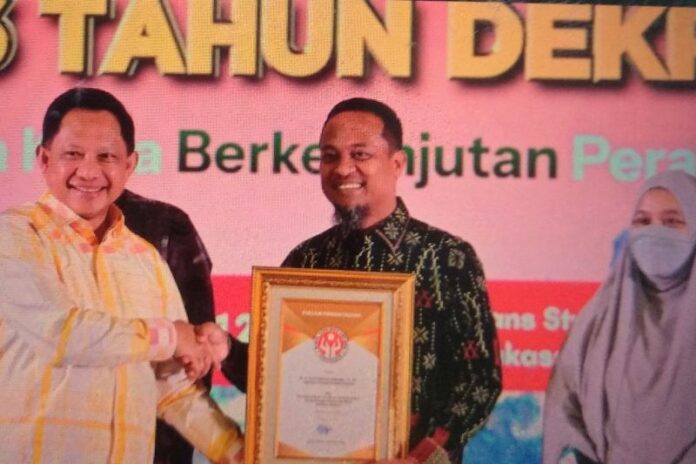 Mendagri Tito Karnavian menyerahkan penghargaan kepada Gubernur Sulsel, Andi Sudirman Sulaiman di Makassar, Minggu,(12/7/2026). Foto: Antara.